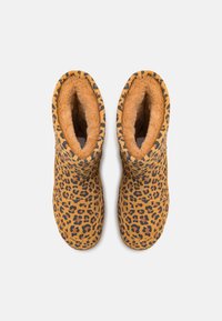 Bottes à imprimé léopard dans une couleur beige chaud, avec une doublure en fourrure douce et une texture lisse. Forme arrondie avec une hauteur mi-mollet.