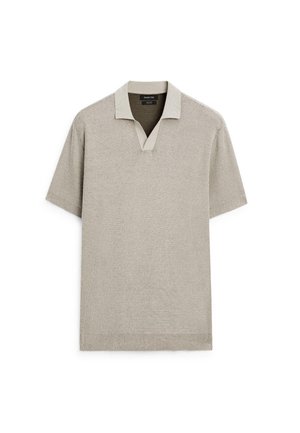 Polo a maniche corte di colore beige chiaro, con texture a maglia, collo a contrasto, design a V e orlo a coste.