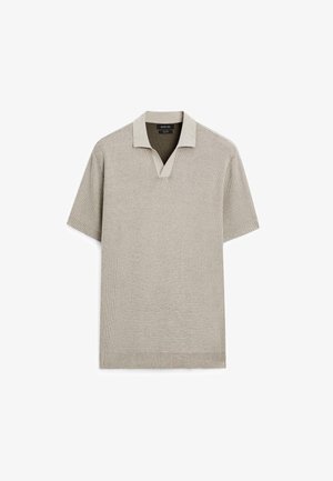 Korte mouw polo in lichtbeige, gebreide textuur, contrasterende kraag, V-hals ontwerp en geribbelde zoom.