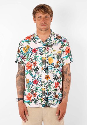 Chemise à manches courtes avec un fond rose pastel et un motif floral dense de couleurs variées. Devant à boutons et détail de poche poitrine.