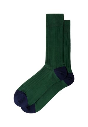 Paar dunkelgrüne gerippte Socken mit marineblauen Zehen- und Fersenbereichen, flach ausgelegt und überlappend auf weißem Hintergrund.