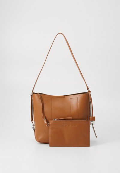 Brown leather shoulder bag with a curved shape, featuring vertical stitching and a detachable zippered pouch. Smooth texture, minimalist design.