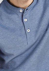 Short-sleeve blue henley shirt made from textured fabric, featuring two buttons and a collar with a casual fit.