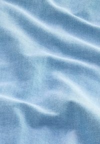 Helles blaues Gewebe mit glatter Textur, das subtile Falten und ein feines Webmuster aufweist, das ein sanftes, fließendes Aussehen erzeugt.