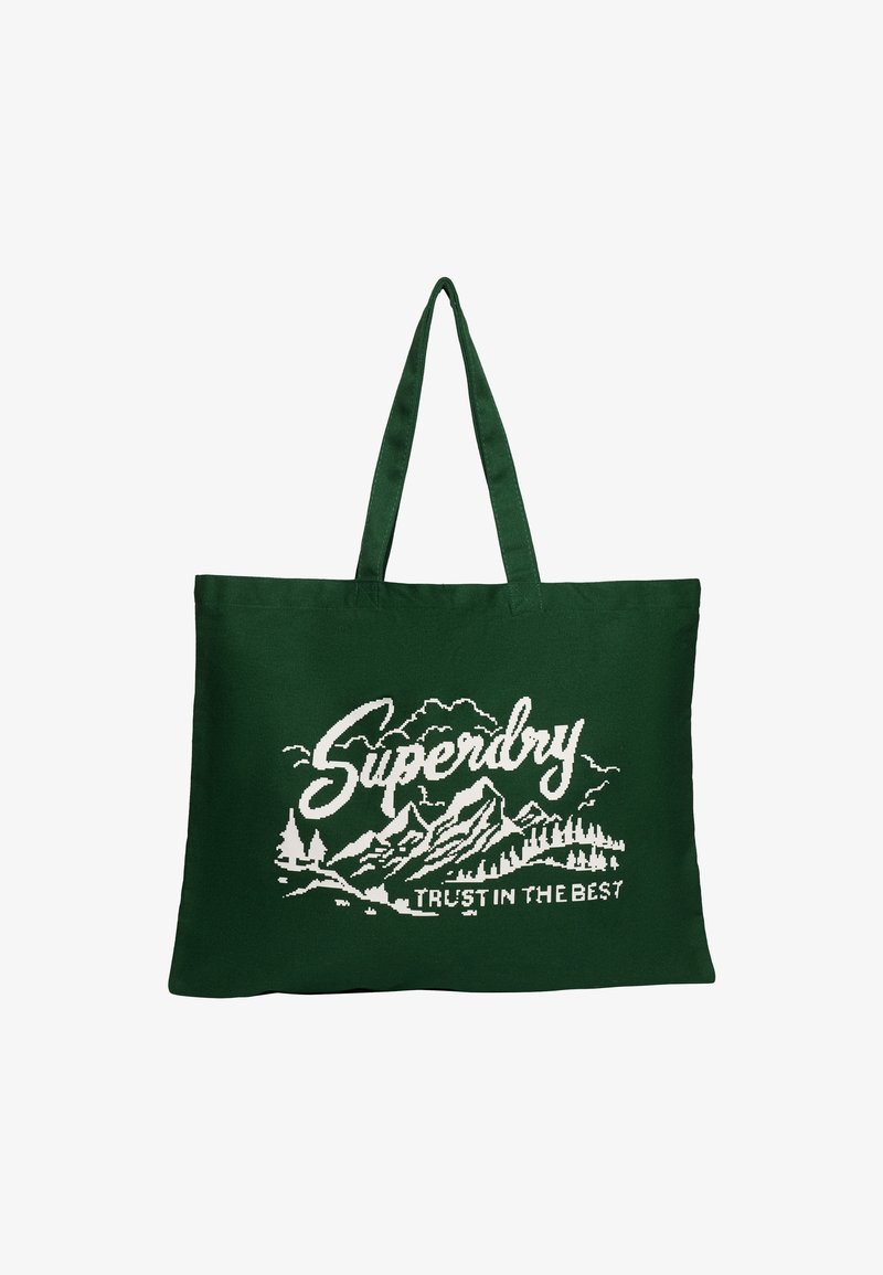 Sac en toile vert avec deux poignées, présentant un design graphique blanc de montagnes et d'arbres, avec le texte "Superdry" au-dessus.