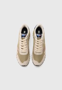 Ζευγάρι μπεζ και ελιάς αθλητικά παπούτσια με κορδόνια, μαύρες σόλες και λογότυπο Blauer USA στη γλώσσα, εμφανιζόμενα από πάνω σε λευκό φόντο.