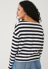 Zwart-witte gestreepte langemouwen shirt met een iets wijde halslijn en een ontspannen pasvorm, gemaakt van zachte katoen.
