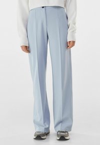 Light blue, high-waisted trousers with a straight-leg design, smooth texture, and front pleats. Button closure and pockets on the sides.