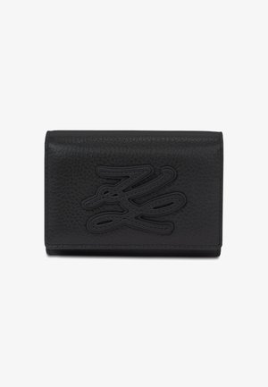 Melnas teksturētas ādas maku ar reljefu stilizētu logotipu priekšpusē, taisnstūrveida un kompakts ar šūtiem malām.