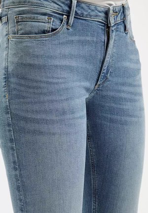 Jasnoniebieskie dżinsy o wąskim kroju, z tradycyjnym pięciopocketowym wzorem, delikatnym wyblaknięciem oraz metalowym zapięciem na zamek.