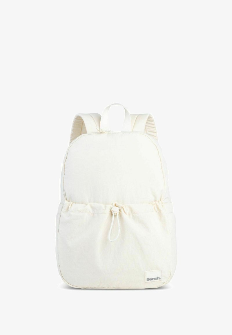 White fabric backpack with padded straps, rounded shape, cinch closure at the front pocket, and minimal branding tag at the bottom.
