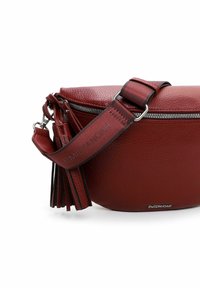 Bolso de hombro rojo de cuero con forma redondeada, cremallera plateada y superficie texturizada. Presenta un borlón y una correa con detalles de logo.