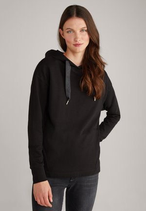 Hoodie noir en matériau doux avec une poche kangourou, une capuche à cordon de serrage et un détail logo subtil sur la manche gauche.