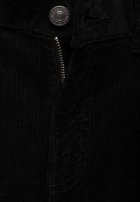 Zwarte corduroy stof met gestructureerde ribbels, voorzien van een ritssluiting en een ronde metalen knop in de taille.