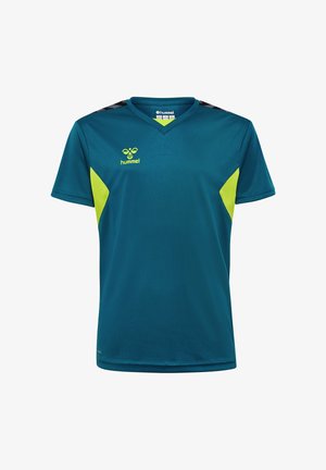 To børn i turkis sportswear med gule accenter, stående og kiggende på hinanden mod en ensfarvet baggrund.