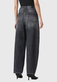 Hoge taille zwarte denim broek met wijde pijpen en een vervaagde afwerking, vijf zakken en gestikte details op de tailleband en de zoom.