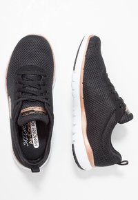 Czarne buty sportowe z oddychającą, siateczkową cholewką, ozdobione akcentem w kolorze różowego złota oraz białą gumową podeszwą z teksturowanym bieżnikiem.