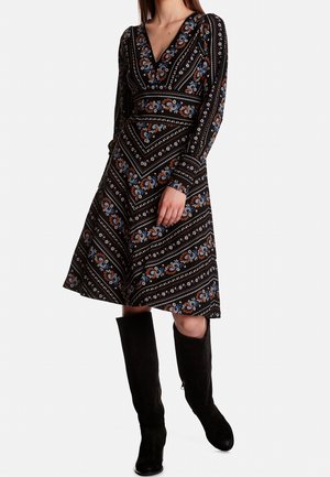 Robe noire avec un col en V, des manches longues et une jupe évasée. Elle présente un motif floral avec des accents bleus et marron ainsi qu'un tissu texturé.