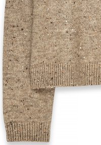 Khakī adīti svārki ar punktētu tekstūru. Apaļš izgriezums un ribotie aproces. Materiāls šķiet maigs un silts, piemērots vēsākam laikam.