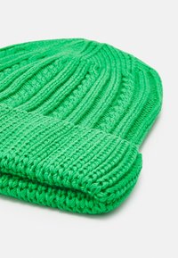 Gorro de lã verde tricotado, com um padrão canelado, aba dobrável e um tecido macio e espesso para aquecer.
