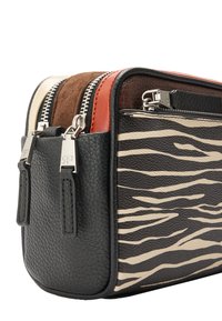 Kompaktowa skórzana torba z czarną, ziarnistą fakturą i wzorem w paski zebry. Wyposażona w zamki w kontrastujących kolorach oraz srebrne okucia.