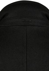 Abrigo de lana negro con un cuello alto, corte recto y sutiles detalles de costura. Etiqueta de la marca "HECHTER" visible en la parte posterior.