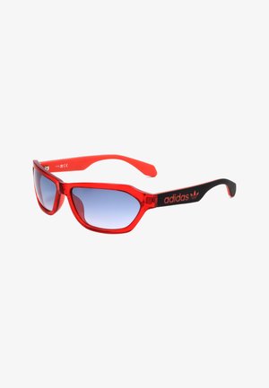 Occhiali da sole Adidas rossi e neri con lenti sfumate blu e logo Adidas sulle aste nere.
