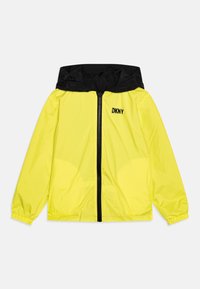 Kirkas keltainen sadetakki mustalla hupulla. Varustettu täyspitkällä vetoketjulla, joustavilla hihansuilla ja DKNY-logolla rinnassa. Kevyt materiaali.