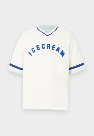 Fehér rövid ujjú ing, amelyen a mellkason kék, ívelt "ICECREAM" felirat található, az ujjmandzsettákon és a V-nyakú galléron pedig kék, krémszínű és világoskék csíkok futnak.