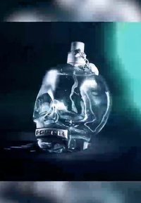 Bouteille en verre transparent en forme de crâne, dotée d'un bouchon en métal et d'une étiquette noire avec "POLICE" imprimé. Texture brillante.