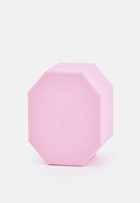 Boîte octogonale rose avec une surface texturée et un logo en relief, présentant un couvercle plat et des bords légèrement arrondis.