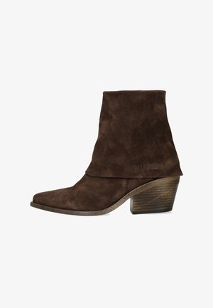 Stivaletto alla caviglia in suede marrone con gambale piegato, punta appuntita e tacco a blocco in legno.