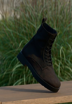 Black leather ankle boot with a sturdy sole, featuring a lace-up front and a loop at the heel for easy wear. Textured surface detail.