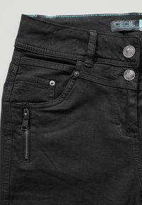 Jeans negros de mezclilla con un bolsillo con cremallera, cierre de doble botón y costuras en turquesa en la cinturilla.