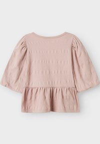 Světle růžový top s balónovými rukávy, peplum lemováním, strukturovanou tkaninou a kulatým výstřihem. Žádné viditelné zapínání ani vzory.