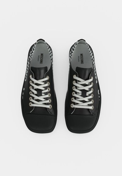 Paire de baskets en cuir Moschino Milano noires avec lacets blancs et logo blanc visible sur les côtés, vue de dessus.