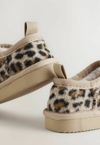 Leopárdmintás slip-on cipők puha műszőr belsővel, bézs részletekkel és texturált talppal a tapadás érdekében. Könnyű és laza dizájn.