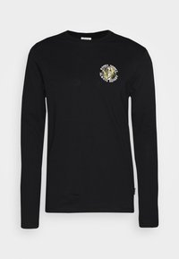 Zwarte t-shirt met lange mouwen van katoen. Heeft een ronde halslijn en een grafische print van een leeuw met tekst op de borst.