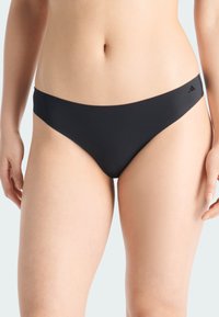 Svart bikiniunderdel med en smidig elastisk midjeband, minimalistisk design och en liten logotypdetalj på sidan. Tillverkad av stretchigt material.