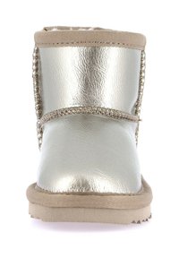 Stivale invernale argentato metallico con rifiniture beige, dettagli cuciti e suola piatta, mostrato frontalmente.