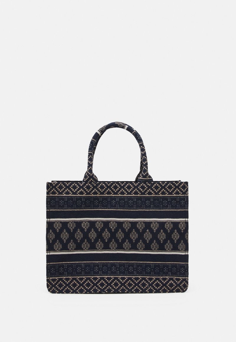 Sac fourre-tout rectangulaire en tissu bleu marine avec des rayures géométriques et florales beige à motifs, doté de deux poignées courtes.