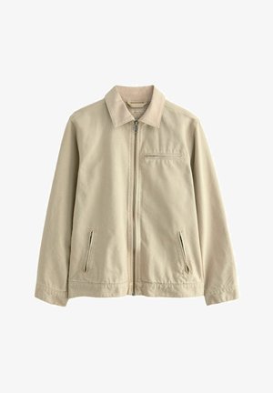Chaqueta de algodón beige con cuello, cierre frontal y dos bolsillos laterales con cremallera. Cuenta con un pequeño bolsillo en el pecho con cremallera. Textura suave.