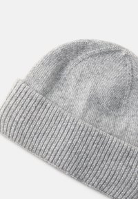 Γκρι πλεκτή σκούφια με υφή, διαθέτοντας διπλωμένο ribbed μανίκι και λείο κορυφή, φτιαγμένη από μαλακό μείγμα μάλλινου υλικού.