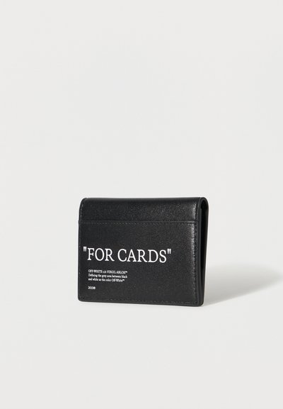 Porte-cartes en cuir noir avec le texte blanc « FOR CARDS » et un petit texte de marque sur un fond clair uni.