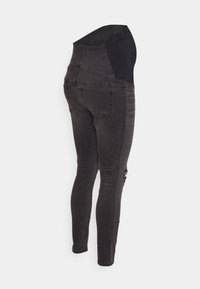 Calças de maternidade em denim preto com uma cintura elástica alta, corte slim, apresentando bolsos traseiros e um detalhe desgastado numa das pernas.