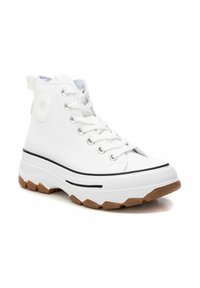 Sneaker alte bianche in materiale di tela, suola in gomma e dettagli neri. Presenta occhielli argentati e un logo circolare sul lato.