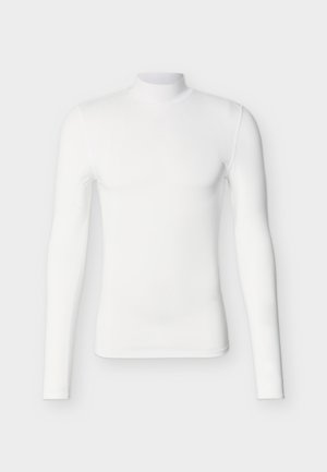 Biela priliehavá košeľa s dlhými rukávmi a vysokým stojačikom, položená natesno na svetlom pozadí, zobrazená spredu aj s rukávmi.