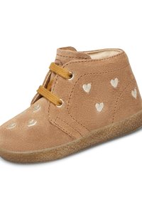 Stivale alla caviglia in suede color sabbia con un interno morbido, caratterizzato da motivi a cuore argentati, punta rotonda e suola in gomma beige con finitura testurizzata.