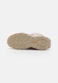 Suela de zapato de senderismo beige claro con un patrón de superficie texturizado, que presenta un distintivo logo de Continental y un diseño de agarre angular para tracción.