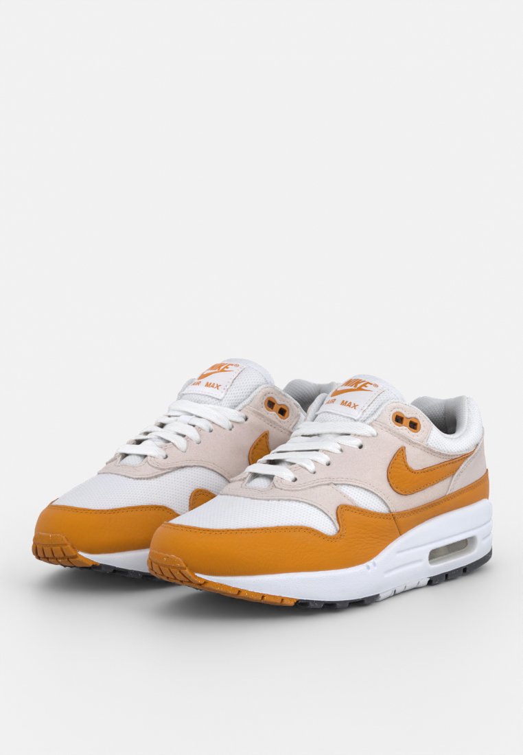 Witte en oranje Nike Air Max sneakers met een bovenwerk van mesh en leer, benadrukt door een zichtbare luchtkussen en een geprofileerde rubberen zool.